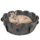 Eine hellfarbige Katze, die in einem dunkelgrauen Filz-Haustierbett in Blumenform liegt, mit dem Logo 'CanadianCat', das an der Seite sichtbar ist.