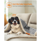 Ein glücklicher schwarz-weißer Hund kuschelt sich unter eine graue Decke auf einem Sofa, mit Text darüber: "Komfortabel kuscheln" und "Hält Ihren Fellfreund warm."