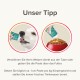 Un chiot blanc reçoit de la pâte d'un tube, tandis qu'une autre image montre la pâte ajoutée à des croquettes, avec un texte allemand offrant des conseils d'alimentation pour chiots.