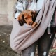 Eine Person in einer karierten Jacke hält einen kleinen Hund in einer weichen, beigen Haustiertragetasche, die eine gemütliche Transportoption für Haustiere zeigt.