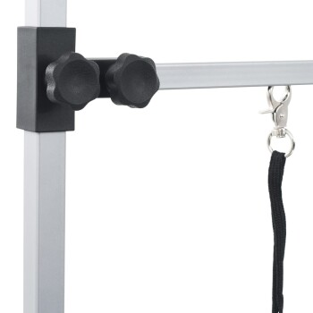 Nahaufnahme eines Befestigungssystems für Haustierleinen mit zwei schwarzen Knöpfen zur Anpassung und einem silbernen Clip zur Sicherung der Leine.