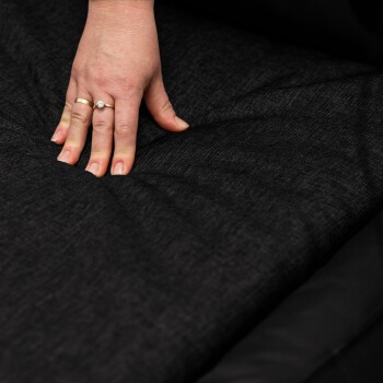 Vier Hunde, darunter zwei Weimaraner, ein schokoladenfarbener Labrador und ein Deutscher Kurzhaarpointer, entspannen auf einem roten Hundebett drinnen.