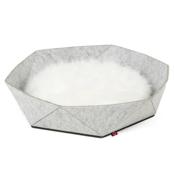 Grau gefilztes Haustierbett mit einem flauschigen weißen Innenraum, in oktagonalem Design und mit einem kleinen roten Etikett an der Seite.