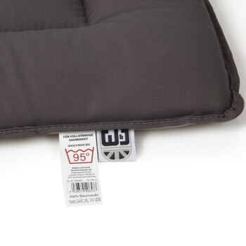 Graues Haustierbett mit einem Etikett, das Waschhinweise bei 95°C zeigt, aus 100% Baumwolle, von Wallace und Jones.
