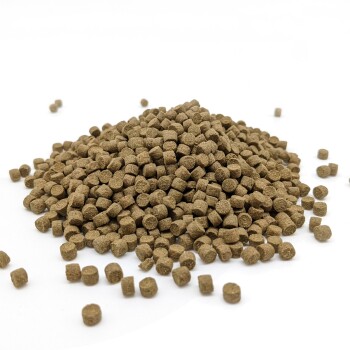 Ein Haufen kleiner, brauner, quadratischer Tierfutterpellets auf einem weißen Hintergrund.