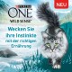 Eine graue Katze mit grünen Augen läuft in der Natur, mit dem Text, der Purina ONE Wild Sense bewirbt.