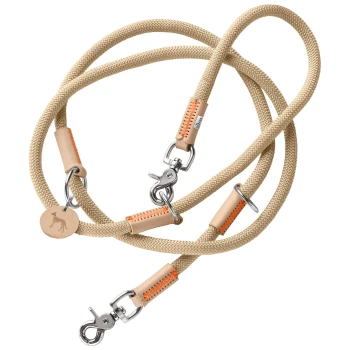 Eine beige Hundeleine aus strapazierfähigem Seil, mit Lederakzenten und orangefarbenen Nähten, mit Metallclips zur Befestigung.
