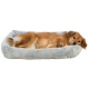 Ein Golden Retriever-Mix liegt bequem in einem weichen, grauen Haustierbett mit Pfotenabdruckdesigns und sieht entspannt und zufrieden aus.