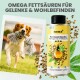 Ein verspielter Hund springt in einem grasbewachsenen Feld mit einem Seilspielzeug, neben einer Flasche Premium Hanföl für Gelenk- und Wohlbefindensvorteile.