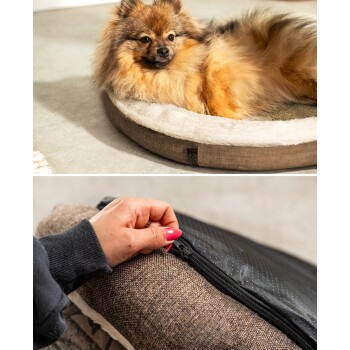 Ein flauschiger Pomeranian entspannt sich auf einem runden Hundebett, während eine Hand den abnehmbaren Bezug aufzippt und das praktische Design hervorhebt.
