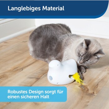 Eine graue Katze spielt mit einem weißen Spielzeug mit einer gelben Feder auf einem Holzboden. Text: "Langlebiges Material" und "Robustes Design für sicheren Halt."