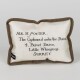 Small rectangular pillow with brown trim embroidered with "Mr. H. Potter, The Cupboard under the Stairs, 4 Privet Drive, Little Whinging, Surrey"