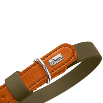 Nahaufnahme eines orangefarbenen Lederhundehalsbands mit silbernem D-Ring, Metall-Logoplatte 'HUNTER' und olivbraunem Riemen.