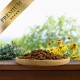 Holzschale gefüllt mit Premium-Haustierfutter auf einer Holzoberfläche mit grünen Pflanzen und gelben Blumen im Hintergrund.
