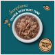 Eine weiße Schüssel mit zerriebenem Lachs und Thunfisch in Soße, mit "Üppiger Lachs mit leckerem Thunfisch" darüber und einem "Richtiges Fleisch"-Abzeichen darunter.
