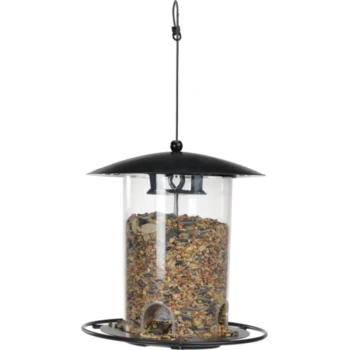 A transparent bird feeder filled with mixed seeds, featuring a black metal roof and base, suspended by a hook.