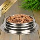 Eine Edelstahlschüssel für Haustierfutter, gefüllt mit hochwertigem Nassfutter für Hunde, mit einem goldenen "PREMIUM"-Label in der Ecke.