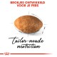 Ein braunes Futterstück auf weißem Hintergrund, mit fettem roten Text "Brokjes ontwikkeld voor je pers" und elegantem schwarzen "maßgeschneiderte Ernährung" darunter.