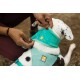 Eine Person passt ein türkisfarbenes Hundebandana an einem gescheckten Hund an, das das Ruffwear-Logo sowohl auf dem Bandana als auch auf dem Geschirr zeigt.