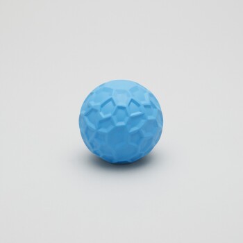 Ein strukturierter blauer Gummiball, der für Haustiere entworfen wurde, mit einem Wabenmuster, vor einem schlichten weißen Hintergrund.