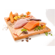 Ein Holzschneidebrett hält frische Zutaten für Tierfutter: Lachs, Huhn, Süßkartoffel, Erbsen, Apfel, Ingwer, Honig und Kräuter.