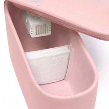 Innenansicht eines rosa Trinkbrunnens für Haustiere mit weißer Filtermatte und kleinem Pumpengehäuse, markiert mit 'UP'.