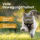 Eine graue Katze in einem schwarzen Geschirr läuft auf Gras, mit dem Text "Volle Bewegungsfreiheit. Leicht und bequem. Freie Schultergelenke."