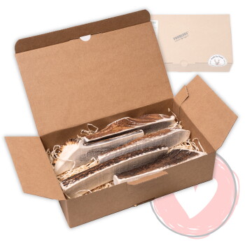 Offener brauner Karton mit Geweih-Kausnacks auf Papierstreu; im Hintergrund eine geschlossene Kiste mit der Aufschrift 'FOURLEGS'.