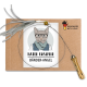 Ein handgemachtes Haustierzubehör-Paket mit einem kreisförmigen Draht mit einem Holzgriff, beschriftet mit "KATER KASIMIR BÄNDER-ANGEL," auf einem braunen Hintergrund.