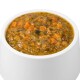 Eine weiße Haustierfutterschüssel gefüllt mit einem dicken, stückigen Eintopf, der orange und grüne Gemüse enthält, wahrscheinlich für Hunde oder Katzen.