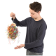 Eine Person hält ein buntes Haustierspielzeug aus zerrissenem Papier und einem Holzsockel, das sein lebhaftes Design zeigt.