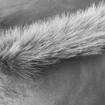 Nahaufnahme von weichem, flauschigem grauem Fell auf einer glatten Oberfläche, das die Textur und den Glanz des Fells hervorhebt.