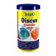 Tetra Discus Granules container with colorful discus fish illustrations and text on complete nutrition for health and growth.
