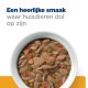 Een kom huisdierenvoer met stukjes vlees, erwten, wortelen en rijst, met de tekst "Een heerlijke smaak waar huisdieren dol op zijn" erboven.