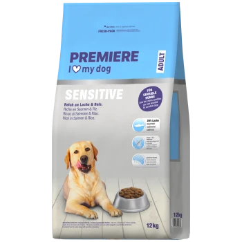 Sac de nourriture pour chien bleu-gris étiqueté « PREMIERE I ♥ my dog » — SENSITIVE, riche en saumon & riz, ADULT, 12 kg ; photo d'un chien avec une gamelle.