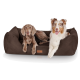 Zwei Hunde, die zusammen auf einem plüschigen, braunen Haustierbett liegen, einer mit hellbraunem Fell und der andere mit weiß-braunem Fell, beide sehen zufrieden aus.