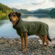 Ein Hund mit einem braun-schwarzen Fell wird von hinten gesehen, trägt einen weichen, olivgrünen Haustiermantel vor einem schlichten weißen Hintergrund.