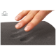 Eine Hand drückt sanft auf eine dunkle, strukturierte Oberfläche und hinterlässt einen Abdruck, der die Weichheit und Reaktionsfähigkeit des Materials zeigt.