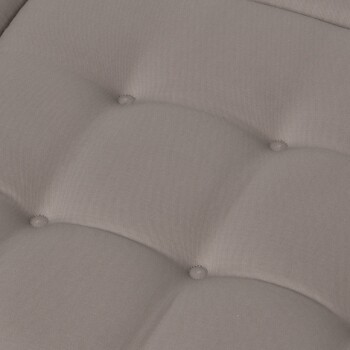 Nahaufnahme eines weichen, gepolsterten Haustierbettes aus hellgrauem Stoff, mit Knopfdetails auf der Oberfläche.