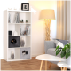 Modernes Wohnzimmer mit einem weißen Bücherregal, zwei Katzen in grauen Kisten, einer stilvollen Stehlampe und einem grauen Sofa mit Kissen.