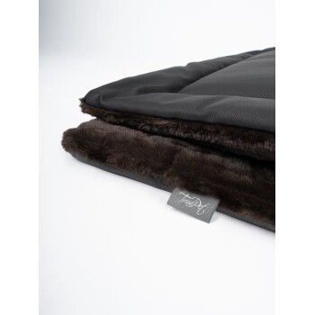 Eine gefaltete Haustierdecke mit einer glatten schwarzen Außenseite und einem weichen, dunkelbraunen Kunstfell-Innenfutter, mit einem kleinen sichtbaren Etikett.