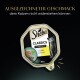 Verpackung von Sheba Classics Katzenfutter mit einer schwarzen Katze, mit dem Text "AUSGEZEICHNETER GESCHMACK" und "mit Kalb und Huhn," 85g.