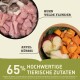 Bild von Haustierfutter-Zutaten mit rohem Hähnchen, wildem Flunder, Apfel und Kürbis. Text hebt "65% hochwertige tierische Zutaten" hervor.