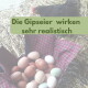 Korb mit gemischten Eiern auf kariertem Tuch und einer schwarzen Henne; Überlagerungstext: "Die Gipseier wirken sehr realistisch".
