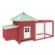 Rotes Holz-Haustierhaus mit einem grünen Dach, das eine kleine Tür und einen angehängten eingezäunten Bereich für den Außenbereich aufweist.