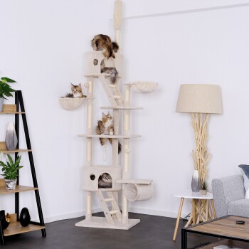Ein hoher, beiger Kratzbaum für Katzen mit mehreren Ebenen und Plattformen, auf dem vier Katzen spielen und sich ausruhen, in einem modernen Wohnzimmer.
