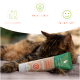 Eine entspannte Katze legt ihren Kopf auf eine Tube "Katzen Vitamin Paste", beschriftet mit "Natural Immun Active", die Gesundheit und Wohlbefinden fördert.
