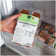 Hand hält eine gefrorene Schale mit Hundefutter, beschriftet 'Komplett‑Mix Senior Rind & Huhn' (400 g), in einem Gefrierschrank