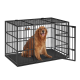 Ein glücklicher Golden Retriever sitzt in einer schwarzen Metallhundekiste mit offener Tür, mit einem stabilen Boden und vertikalen Stäben.