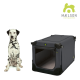 Eine schwarze Hundebox mit weichem Innenraum, mit einer Frontöffnung, neben einem sitzenden Dalmatiner. MÆLSON-Logo sichtbar.